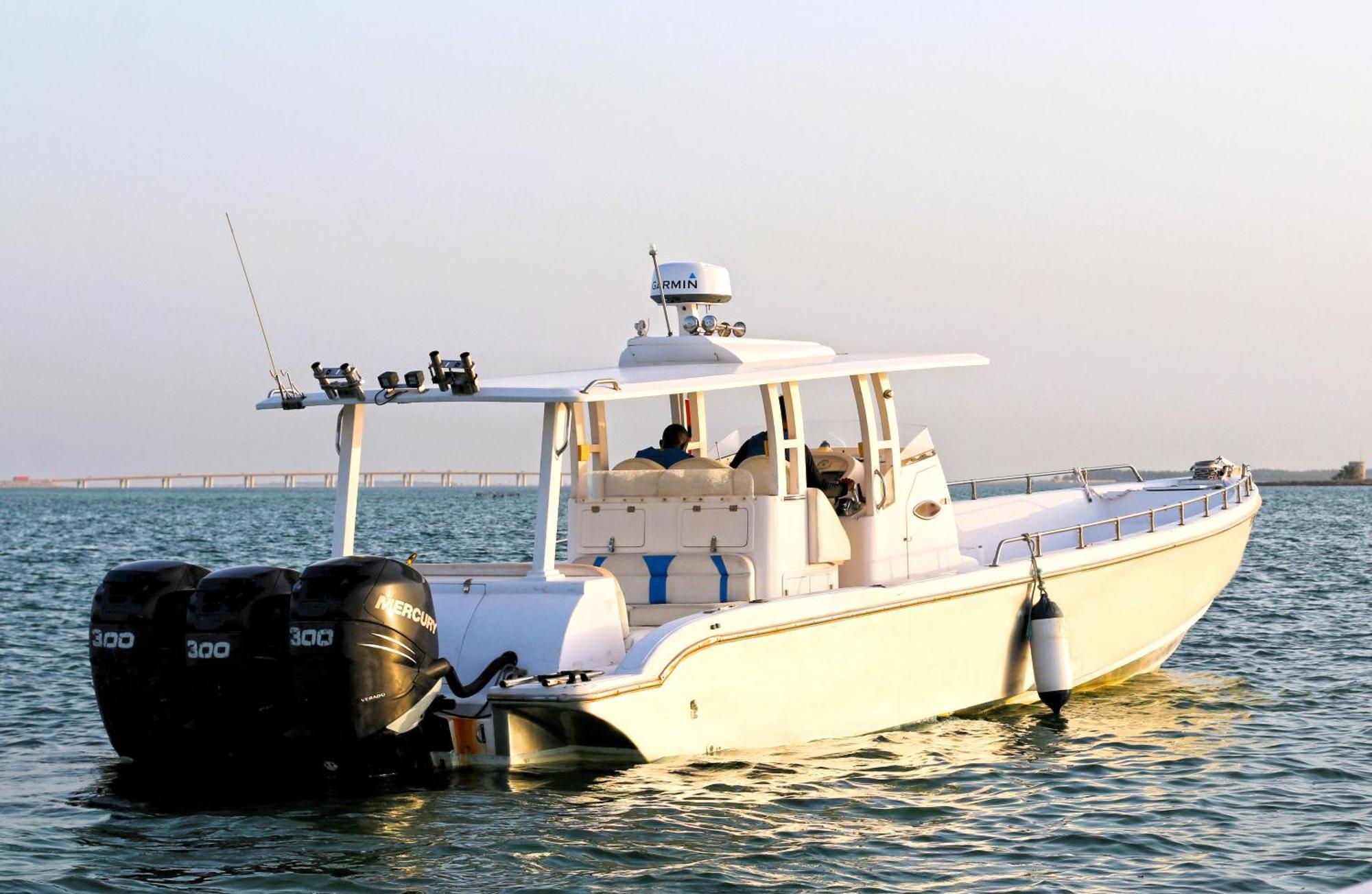 Lagoona Beach Luxury Resort And Spa Manáma Exteriér fotografie The photo shows a large, white motorboat equipped with three powerful outboard engines at the stern. The boat has a sleek design, with a spacious open deck and a covered cabin area that likely provides shelter and controls for navigation. The scene i