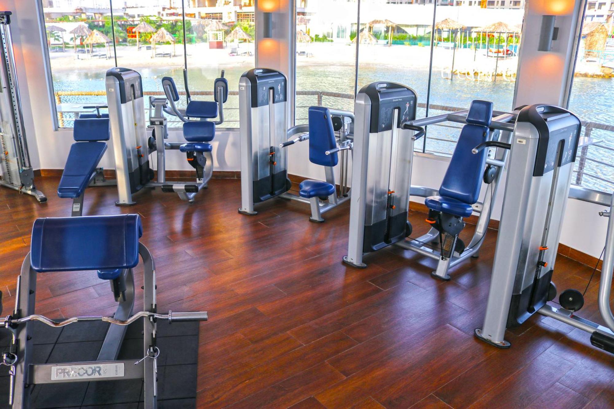 Lagoona Beach Luxury Resort And Spa Manáma Exteriér fotografie The photo shows a gym or fitness center with several pieces of exercise equipment. There are multiple machines designed for strength training, including seated machines with padded seats and backrests. The equipment appears to have a modern design an