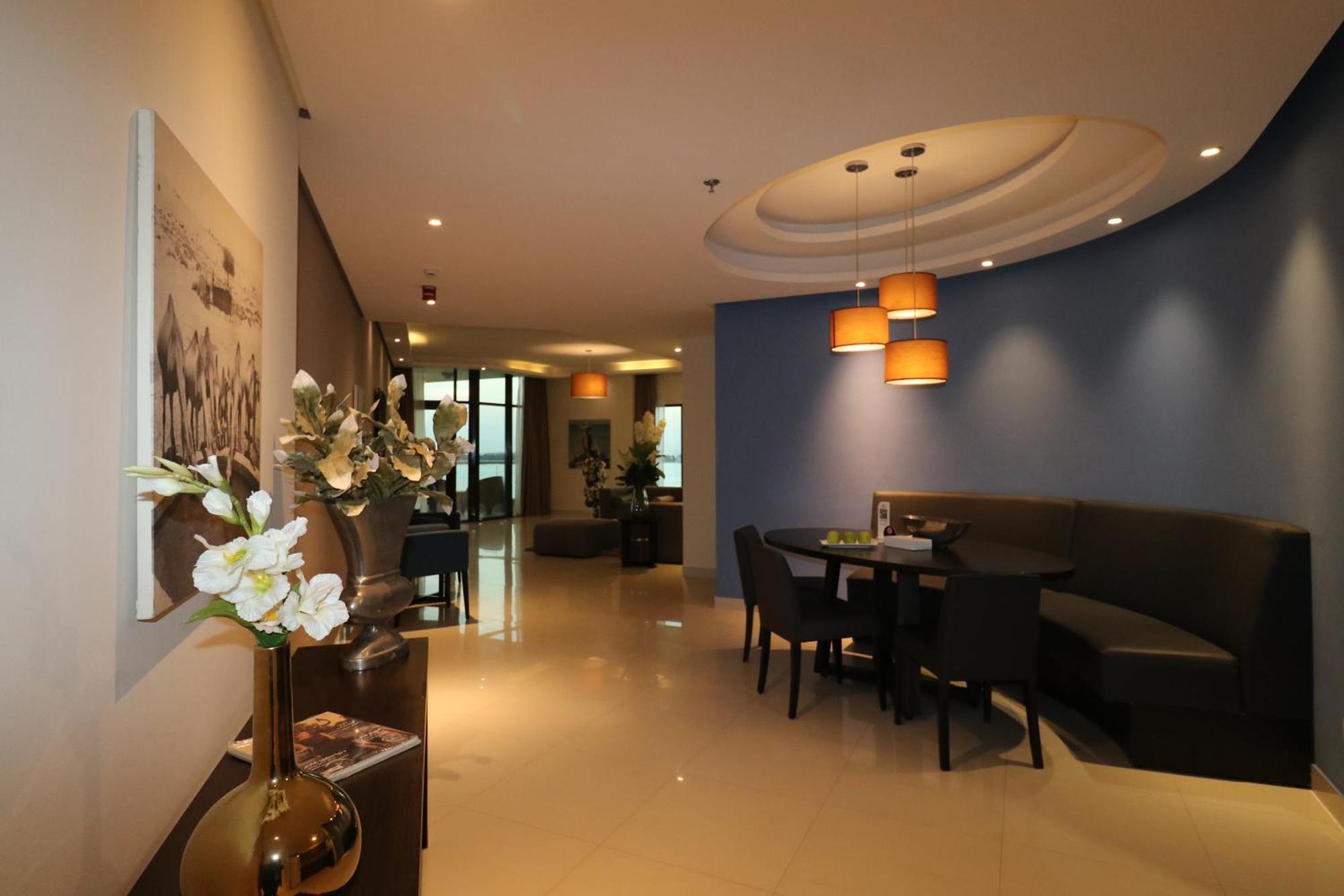 Lagoona Beach Luxury Resort And Spa Manáma Exteriér fotografie The photo showcases an interior space, likely a modern lounge or reception area. It features a combination of soft lighting, neutral-colored walls, and decorative elements. There are elegant light fixtures hanging from the ceiling, and a curved blue 